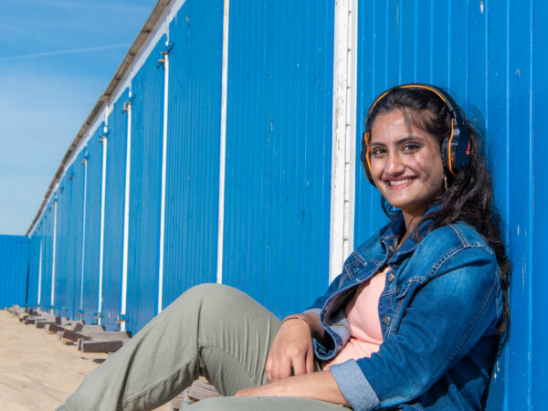 International student Aadya sitting on the beach